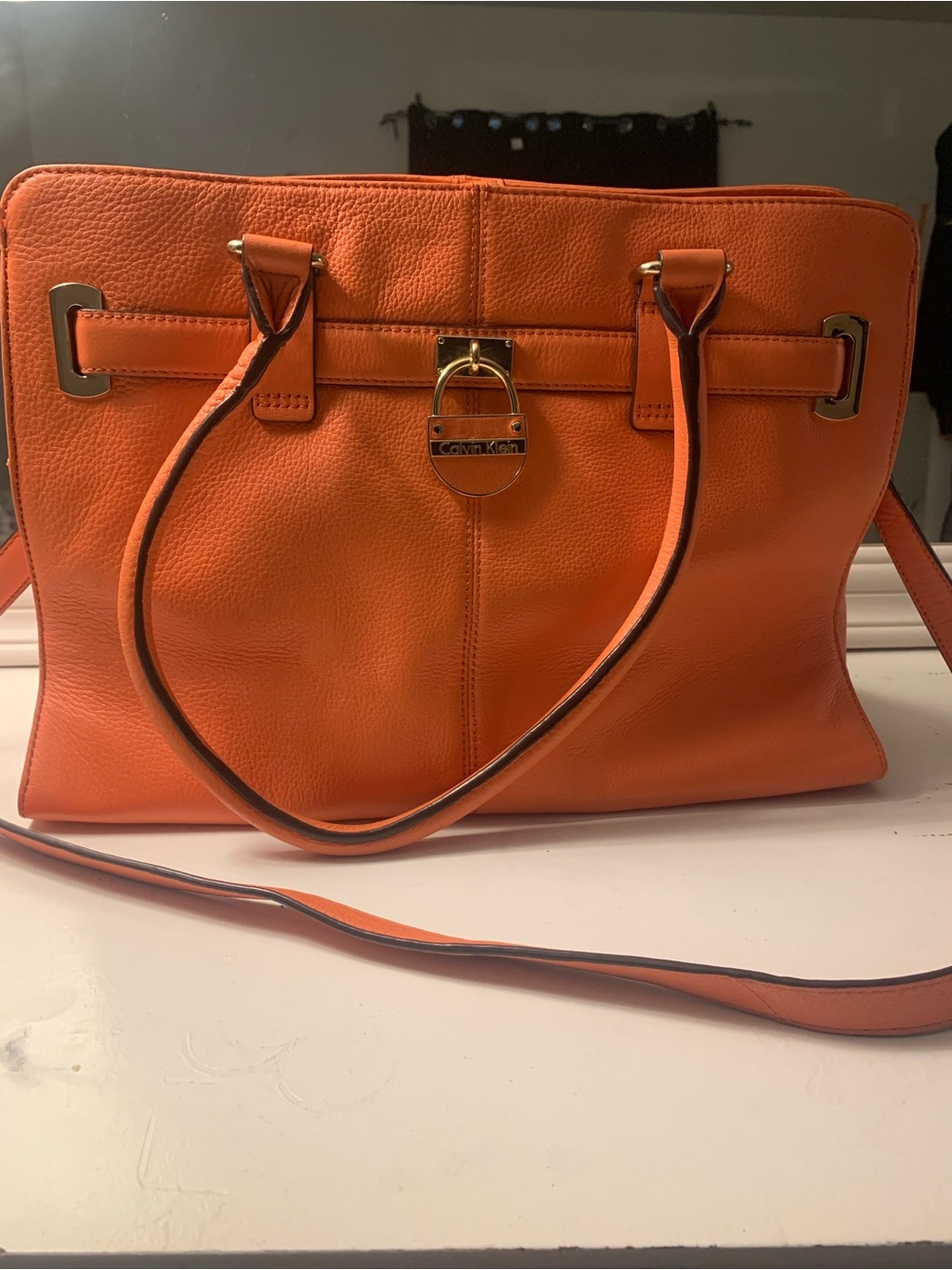 Calvin Klein handbag featuring top handles, crossbody strap & gold-tone hardware